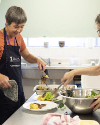 Two volunteers working in a CatholicCare Kitchen.
