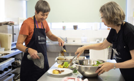 Two volunteers working in a CatholicCare Kitchen.